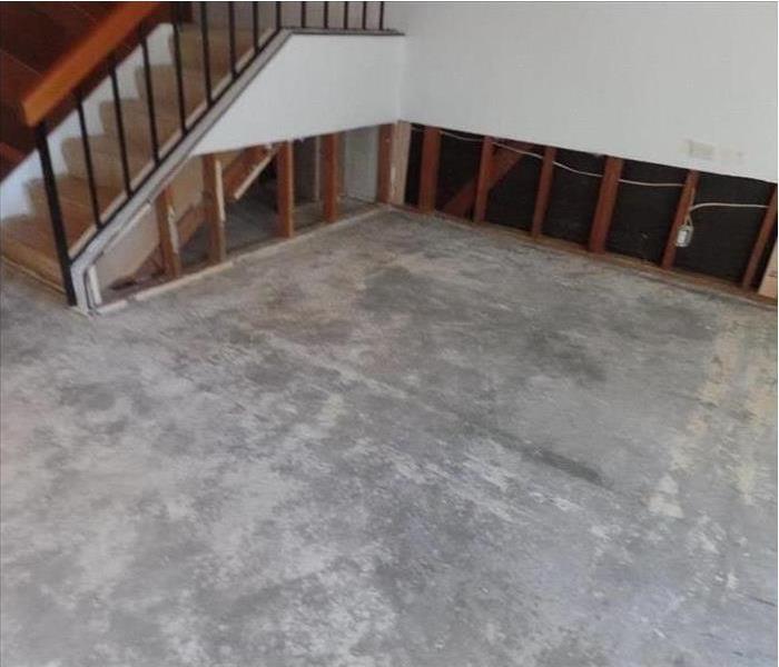 carpet removed showing pad plus some drywall cut out by stairs and side