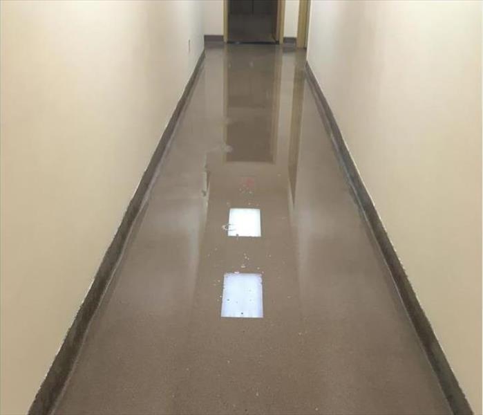 water pooling on hallway, lights reflecting from the ceiling