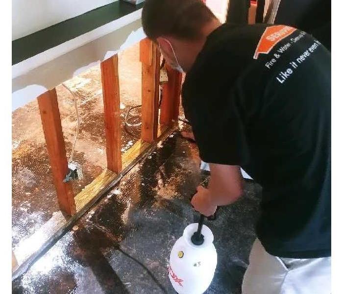 SERVPRO technician with manual fluid extractor