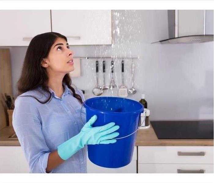 Woman Catching Water in a Bucket
