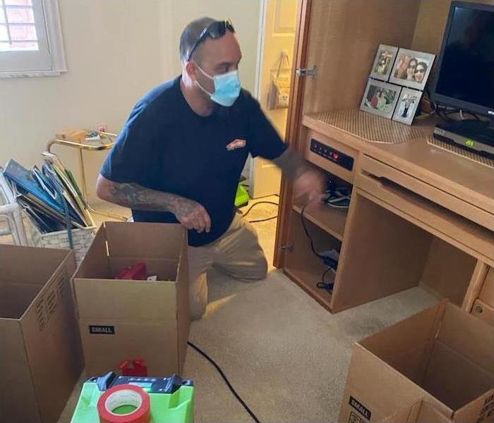 SERVPRO technician packing items into boxes